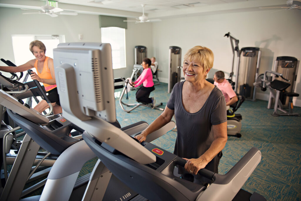 A photo of a woman exercising in the Fitness Center at the Coastal Commons Clubhouse